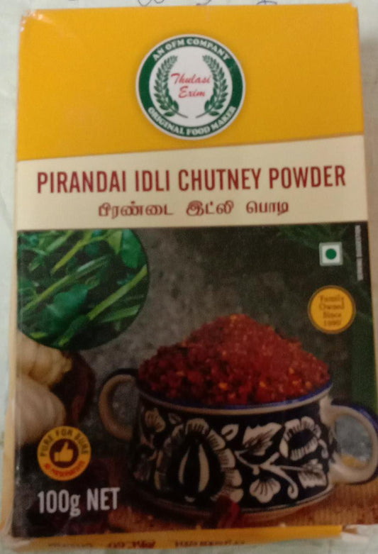 Pirandai Idli Chutney Powder pouch with soft idlis, sesame oil, and fresh pirandai (Adamant Creeper) stems arranged on a banana leaf background