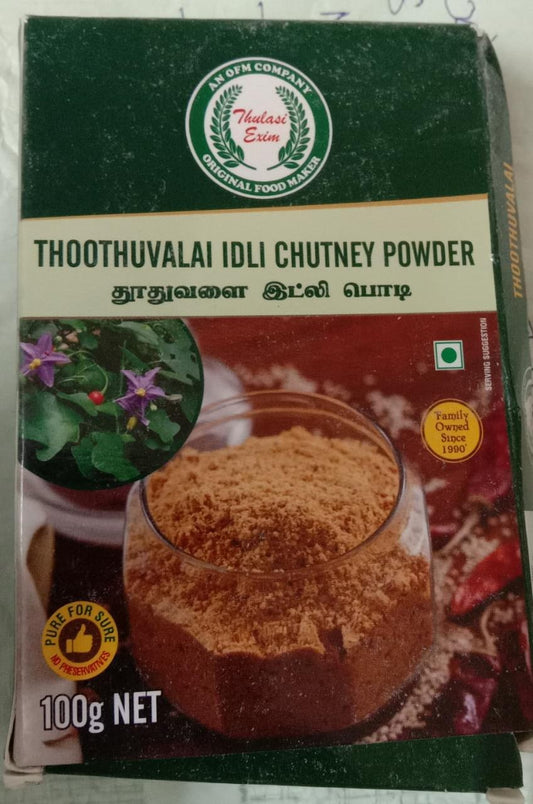 Thoothuvalai Idly Chutney Powder pouch with soft idlis, sesame oil, and fresh thoothuvalai leaves arranged on a banana leaf background
